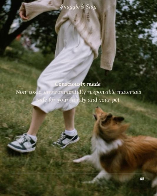 Person in a beige sweater and white pants standing in a grassy area with a dog, promoting environmentally responsible materials.