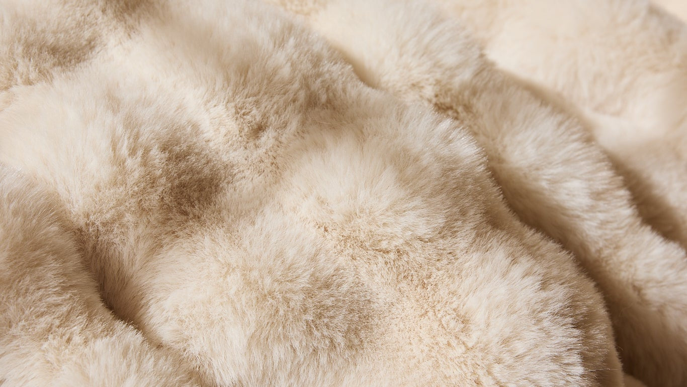 Close-up of beige faux fur fabric texture