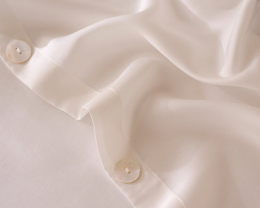 Close-up of a white TENCEL bedding with mother of pearl buttons.